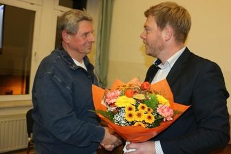 Blumen für ein Urgestein der Feuerwehr im Vogtland - Bürgermeister Michael Pohl gratuliert Wolfgang Rauh (links) zu der Auszeichnung mit der Verdienstmedaille des Landesfeuerwehrverbandes.