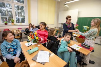 Blumige Aktion: Schülerinnen verschenken in der Plauener Friedensschule Rosen - Liridona und Mayla (rechts) waren die Blumenbotinnen in der Klasse 5a. Auch Lehrerin Silke Bauer freute sich. John (links) hatte ihr bereits einen Brief geschrieben.