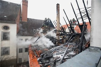Brand in der Freiberg: Ermittlungsergebnisse bis Ende der Woche - Rauchschwaden wabern durch die Luft: Feuerwehrmänner löschen im Dachstuhl, vom dem nur ein Gerippe übrig blieb, Glutnester.