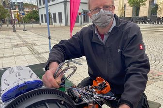 Breitband-Ausbau: 15.000 Haushalte in Zwickau erhalten Glasfaser-Anschluss - Telekom-Monteur Uwe Schädlich zeigt auf dem Zwickauer Hauptmarkt, wie Glasfaserkabel durch ein Schweißgerät miteinander verbunden werden können.