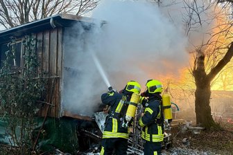 Brennender Bauwagen: Großeinsatz der Feuerwehren in Affalter - Kameraden mit schwerem Atemschutzgerät löschen in Affalter die Flammen.