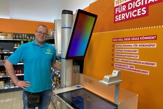 Brot, Butter, Führerschein: So testet der Tante-Enso-Laden in Falkenau jetzt die Digitalisierung - Swen Wunsch, seit gut einem Jahr Marktleiter im Tante-Enso-Laden in Falkenau, am neuen digitalen Bürgerservice-Terminal.