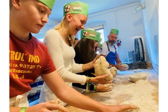 Brot für die Welt: Besondere Backaktion erlebt Auftakt im Erzgebirge - Bäckermeister Marco Wetzel (hinten im Bild) machte es vor und übergab den Konfirmanden dann den portionierten Teig zum Formen.