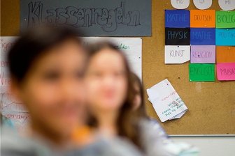 Bündnis plant Volksantrag für längeres gemeinsames Lernen - Klassenregeln und ein Stundenplan hängen in einer Schule an der Wand: Ab welcher Klassenstufe sollen Schüler in Sachsen künftig auf Gymnasium gehen?