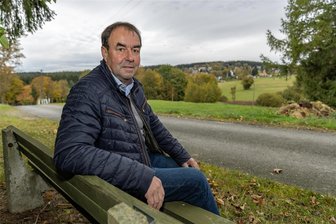 Bürgermeisterwahl Grünbach: Der Titelverteidiger will Schule und Kindergarten stützen - Einer der Lieblingsplätze von Ralf Kretzschmann ist die Bank an der Straße Pfannenstiel. Von dort kann er die Plätze seiner Kindheit sehen - und hat einen guten Blick auf Gebäude in Grünbach, die ihm wichtig sind.