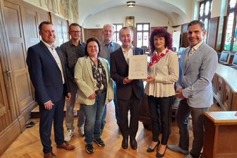 Bürgerstiftung gegründet: Jetzt sind die Treuenerinnen und Treuener gefragt - Treuens Bürgermeisterin Andrea Jedzig erhält aus den Händen des Sparkassen-Vorstandsvorsitzenden Marko Mühlbauer die Stiftungsurkunde. Weiter im Bild sind Mitarbeiter des Geldhauses und des Stiftungsrates zu sehen.