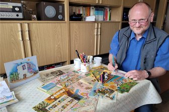 „Bummi“: Roland Reth erfand das Karlchen der DDR-Kult-Zeitschrift - An seinem heimischen Schreibtisch mit alten „Bummi“-Ausgaben: Hier sitzt Roland Reth nachts und zeichnet.