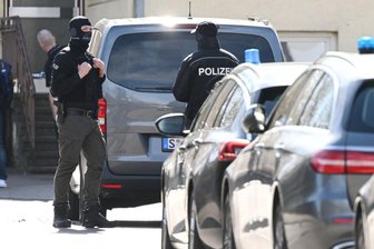 Bundesweite Razzien im "Reichsbürger"-Milieu: Ein Verdächtiger aus Chemnitz - Einsatzkräfte der Polizei stehen an Einsatzfahrzeugen. Bei einer Durchsuchung im Auftrag der Bundesanwaltschaft ist im baden-württembergischen Reutlingen ein Beamter eines Spezialeinsatzkommandos (SEK) durch einen Schuss verletzt worden.