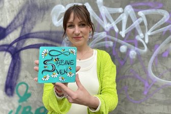 Bunte Kacheln und ein Gemüsegarten: Wie Gewerbetreibende die Peter-Breuer-Straße in Zwickau verschönern wollen - So könnte es aussehen: Sara Linke mit einer Kachel für die „Liebesmauer“.