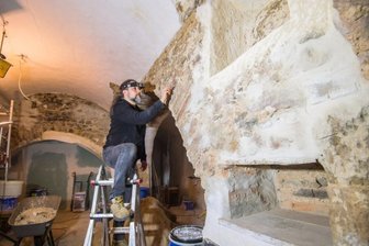 Burgküche aus dem Mittelalter wird jetzt wieder hergerichtet - Restaurator Holger Blauhut hat die Putzschichten in der ehemaligen Burgküche auf der Burg Schönfels untersucht, ehe er gemeinsam mit Museumsmitarbeitern für einen neuen Pinselputz, wie er im Mittelalter üblich war, sorgt. Rechts im Bild sind die gotischen Wandnischen zu sehen, die freigelegt wurden. 