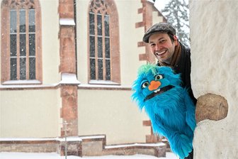 Burgstädt lacht: Mit Ulfie und Sebastian Rochlitzer auf Sockenjagd - Puppenspieler und Bauchredner Sebastian Rochlitzer an der Stadtkirche in Burgstädt mit seinem Ulfie.