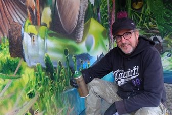 Carolas Garten nun auch in Auerbach - Eine Woche hat der Graffiti-Künstler Tasso gebraucht, um eine gelbe Carportwand in diese grüne Oase zu verwandeln. Die Idee zum Motiv stammt vom Panorama "Carolas Garten - Eine Rückkehr ins Paradies" von Yadegar Asisi, welches derzeit im Panometer Leipzig zu sehen ist.