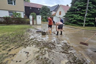 Chef des Rettungszweckverbandes spricht von „Sonderlage“: Unwetter hält Vogtländer in Atem - Anwohner versuchten, den Schlamm von ihren Häusern fernzuhalten.