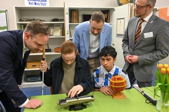 Chemnitz: Geschichte der Blindenschule wird greifbar - Alexander Dierks, Ricardo, Patrick Schreiber vom Landesamt für Schule und Bildung und Schulleiter Michael Theiss (von links) interessieren sich für die Blindenschriftmaschine.