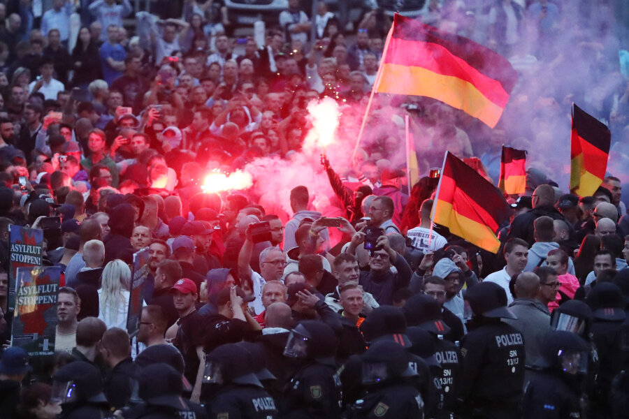 Chemnitzer Polizei zieht Bilanz: Rund 7500 Demonstranten, 600 Einsatzkräfte, 20 Verletzte - Demonstranten der rechten Szene zündeten am Montag in der Chemnitzer Innenstadt Pyrotechnik und schwenkten Deutschlandfahnen. 