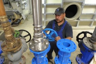 Chemnitzer Stadtbad erhält neuen Wasserspeicher - Steffen Lippmann, Mitarbeiter einer Chemnitzer Baufirma, montiert im Keller unter dem Foyer des Stadtbades Leitungsteile. Hinter ihm rechts steht der neue Tiefspeicher aus Kunststoff für die täglich verbrauchte Wassermenge von bis zu 100 Kubikmetern.