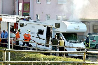 Chemnitzer will Nebenkläger im NSU-Prozess werden - ARCHIV - Feuerwehrleute und Polizisten stehen am 04.11.2011 in Eisenach vor einem qualmenden Wohnwagen, in dem zwei Leichen entdeckt wurden. Die Polizeimaßnahmen unmittelbar nach dem Auffliegen der rechten Terrorzelle «Nationalsozialistischer Untergrund» (NSU) am 4. November 2011 in Eisenach werfen neue Fragen auf.
