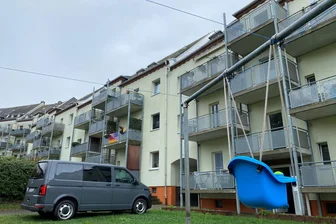 Chemnitzerin wegen Tötung ihres Verlobten vor Gericht: „Wir haben ihn alle vor der Beziehung gewarnt“ - Ermittlungen in Chemnitz: Ein Fahrzeug der Kriminalpolizei im Hof der Wohnanlage, in der sich die Bluttat ereignet hat.
