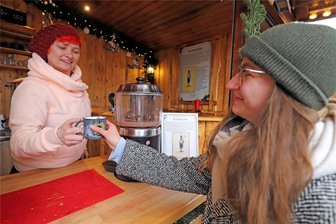 Christmarkt Freiberg im Test: Wie viel kosten Glühwein, Krapfen & Co.? Und sind 50 Zentimeter Bratwurst ein halber Meter? - Bei Ines (l.) am Glühweinstand gibt es verscheidenste heiße Getränke. Für unseren Test entscheiden wir uns für einen Apfel-Zimt-Glühwein.