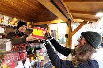 Christmarkt Freiberg im Test: Wo werden Veganer und Vegetarier fündig? - Michelle Putnins (l.) reicht unserer Reporterin Elisa Leimert einen Becher voll Churros.