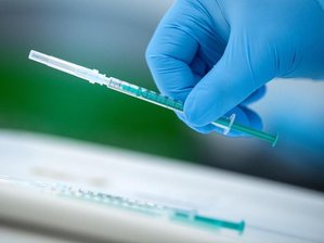 Corona-Hotspot Sachsen bei Erstimpfungen wieder Schlusslicht - Ein Mitarbeiter vom Impfzentrum hält eine Spritze mit dem Covid-19-Impfstoff in der Hand.