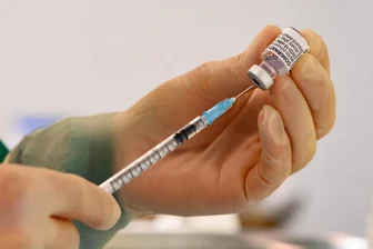 Eine pharmazeutisch-technische Assistentin zieht eine Spritze mit dem Corona-Impfstoff von Biontech/Pfizer auf.