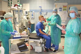 Mitarbeiter des LMK zeigen, wie ein Corona-Test vonstatten geht.