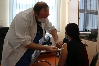 Corona: Knapp 70 Erzgebirger kommen zum Auftakt der Samstagsimpfungen ins Klinikum Aue - Dr. André Klinger impfte am Sonnabend eine junge Frau aus Bernbach gegen das Coronavirus.
