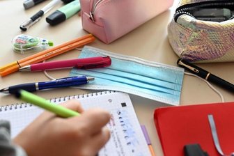 Ein Mund-Nasen-Schutz liegt auf dem Tisch einer Schülerin.