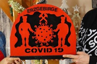 Corona-Lage im Erzgebirge: Stollberger OB polarisiert mit offenem Brief - Sehmaerin überrascht Ehemann mit Corona-Schwibbogen: Weihnachten spielt bei Familie Hertzsch in Sehma eine große Rolle. Ab Totensonntag werden die Zimmer mit weihnachtlicher Dekoration liebevoll geschmückt. Seit Freitag gehört ein besonderer Schwibbogen mit Beleuchtung hinzu: Er soll an die Coronazeit erinnern.  "Als ich nach der Spätschicht nach Hause kam, stand der Schwibbogen auf dem Tisch", berichtet Benjamin Hertzsch. Der 30-Jährige sei erstmal sprachlos gewesen. Seine Frau hatte ihm seinen Wunsch nach einem Bogen mit Corona-Motiv erfüllt, als Erinnerung an das Pandemie-Jahr 2020." Vergangene Woche hat seine Frau Nicki Hertzsch heimlich mit der Laubsägearbeit angefangen. "Zum Erzgebirge gehören nun einmal die Bergmänner, und daher mussten sie auch mit rein." Am Donnerstagabend wurde das Stück fertig. Eigentlich wollte sie ihren Mann zum Nikolaus damit überraschen. "Ich wusste aber nicht, wo ich ihn verstecken sollte, weil er immer alles findet", erklärt die 23-Jährige. "So habe ich ihn einfach auf den Tisch gestellt." Nun muss das junge Paar nur noch einen Platz für den besonderen Schwibbogen finden.  [Nicki Hertzsch aus Sehma hat einen Corona-Schwibbogen für ihren Mann gestaltet.] Thomas Fritzsch Nicki Hertzsch aus Sehma hat einen Corona-Schwibbogen für ihren Mann gestaltet.
