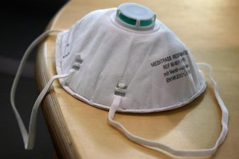           Eine FFP2-Atemschutzmaske liegt auf einem Tisch.