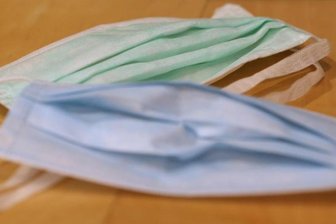            Medizinischer Mundschutz liegt auf einem Tisch.