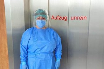 Eine Stationsschwester in voller Schutzkleidung des Kreiskrankenhauses Stollberg vor einem Patientenaufzug, welcher als "unrein" definiert ist und nur für Covid-19-Patienten in Betrieb genommen wird. 
