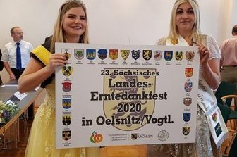 Zwei Majestäten präsentieren das offizielle Ausrichterschild: Sperkenprinzessin Lisa Hohberger (links) und die Vogtländische Kartoffelprinzessin Selina Kohl. Nun fällt das verschobene Landeserntedankfest erneut aus.