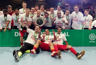 Costa auf der Bühne, Samba auf der Platte: Regensburg Futsal-Meister - Die Spieler vom SSV Jahn 1889 Regensburg jubeln mit der Meisterschale nach ihrem Finalsieg gegen den VFL 05 Hohenstein-Ernstthal bei der Deutschen Futsal-Meisterschaft in Zwickau.