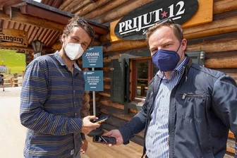 Covid-Ex-Modell in Oberwiesenthal: Die ersten Gäste werden erwartet - Philipp Heinrich, Inhaber des Restaurants "Prijut 12", und Covid-Exit-Projektmanager Erik Schulze (v. l.) demonstrieren, dass im einfachsten Fall ein Smartphone genügt, um sich registrieren zu lassen. 