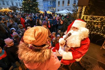 Crimmitschau feiert Weihnachtsmarkt trotz Wetterkapriolen - Für die kleinen Marktbesucher war der Besuch des Weihnachtsmannes, der den großen Adventskalender auf der Bühne öffnete, ein Höhepunkt.