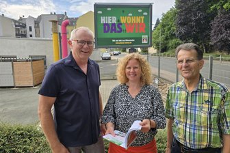 Crimmitschau: Großvermieter setzt weiterhin auf bezahlbare Wohnungen - Bodo Schulze, Jana Schilling und Harald Lichtenstein (Vorstand) vor dem Plakat.
