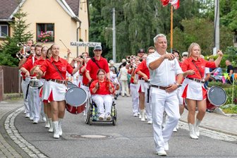 Crimmitschau: Junge Frau musiziert im Rollstuhl im Fanfarenzug - Dunja Altmannshofer (Mitte) spielt die Becken.