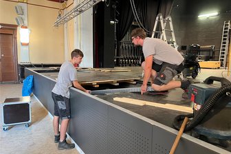 Crimmitschau: Olsenbande weiht neue Bühne im Stadttheater ein - Die neue Bühnenfront ist bereits ein Hingucker. Noch sind aber Jonas Wetzstein (l.) und Chris Walther von der ortsansässigen Firma Elis Elektroinstallation mit dem Verlegen von Kabelleitungen beschäftigt, die vom Mischpult zur Bühne führen.