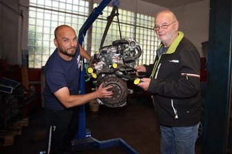 Crimmitschau: Warum ein fast 80-Jähriger noch immer an Autos schraubt - Wenn Not am Mann ist, hilft Ralf Behring (rechts) auch in der Werkstatt mit. Sein Nachfolger Björn Fischer (links) schätzt den Meister für sein Fachwissen und kann sich keinen anderen Arbeitsplatz vorstellen.