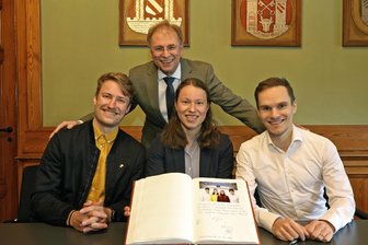 Crimmitschau würdigt seine Olympia-Teilnehmer mit Eintragung ins Ehrenbuch der Stadt - Die Eisschnellläufer Fridtjof Petzold, Josie Hofmann und Felix Maly (von links) trugen sich am Mittwoch unter den Augen von Oberbürgermeister André Raphael (hinten) ins Ehrenbuch der Stadt Crimmitschau ein.
