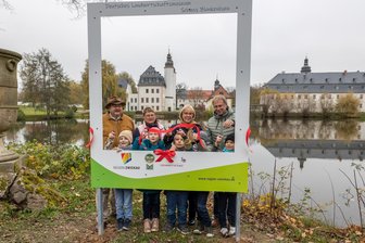 Crimmitschau: XXL-Bilderrahmen am Schloss im Ortsteil Blankenhain aufgestellt - Jürgen Knauss (Museum), Ortsvorsteherin Ulrike Voigt, Angelika Hölzel (Kreis) und OB André Raphael (v. l.) testen mit Schülern die neue Attraktion.