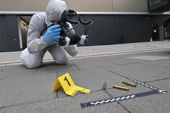 CSI Zwickau: Den Tätern auf der Spur. Wie im Film, doch ganz anders - Die Kamera im Anschlag, die Patronenhülsen mit Spurennummer und Maßstab im Visier: Kriminalobermeister David Clauß demonstriert im Hof der Polizeidirektion Zwickau, wie er am Tatort vorgeht.