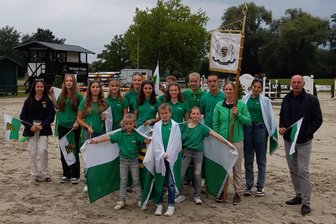 „Da sind wir als kleiner Ostverband ganz stolz“: Fünf vogtländische Reiterinnen beim Bundesnachwuchschampionat der Vielseitigkeit - Von links nach rechts: Das „Adoptivkind“ aus Sachsen-Anhalt (Linnea Kühne), Marie Vogel, Mia Müller, Luna Löschner, Melina Seifert, Julia Reichel, Oscar Gündel, Elena Thieme, Max Haußer-Knabe, Jurij Bobke, Christina Schöniger, Cora Kropf und Landestrainer Manfred Kröber mit kleinen Fans und Geschwistern im Vordergrund.
