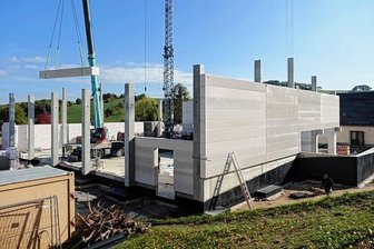 Dach für Turnhalle folgt als nächstes - Noch werden an der neuen Halle die Betonteile per Kran für die Wände in Position gebracht, doch schon bald soll das Dach folgen. 