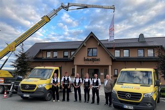 Dachdecker-Meisterbetrieb im Bobenneukirchen: Im Jahr des 90-Jährigen nur ein Neubaudach - Der Dachdeckermeisterbetrieb Rödel mit (von links) Martin Steudel, Rico Steudel, Andreas Reuschel, Karoline Gieschke, Firmeninhaber Daniel Rödel sowie seinem Vater und Vorgänger als Chef, Ulrich Rödel. Kran und Fuhrpark stehen am Restaurant Lokalfilet in Oelsnitz, wo das 90-jährige Bestehen der Firma gefeiert wurde.