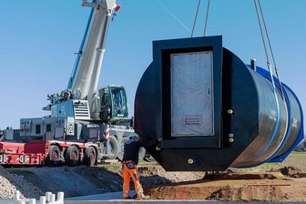 Damit das Trinkwasser besser fließt - Mit dem Autokran wird die Druckerhöhungsanlage mit Saugbehälter neben der Straße zwischen Beedeln und Bernsdorf am für sie vorgesehenen Ort abgesetzt. Der Wasserverband investiert fast 300.000 Euro.