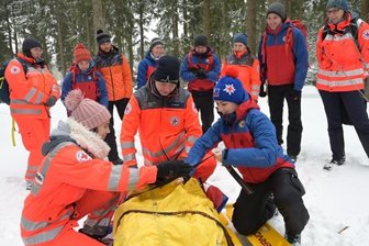 Damit im Notfall jeder Handgriff sitzt: Bergwacht und Rettungsdienste üben gemeinsam - Bianca Naumann von der Rettungshundestaffel, Nick Werner vom DRK-Rettungsdienst Pirna sowie Julia Schönfelder (v. l.) vom Rettungsdienst Aue-Schwarzenberg sichern einen Verletzten für den Transport.