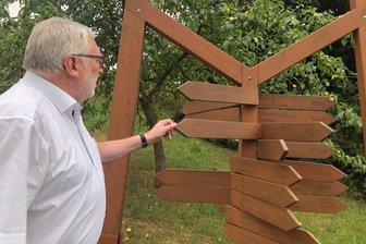 Damm und der Mittelpunkt des Kreises - Matthias Damm am geografischen Mittelpunkt des Landkreises in Cunnersdorf, einem Ortsteil von Hainichen. Die Schilder zeigen Entfernungen zu Städten und Gemeinden in Mittelsachsen. 